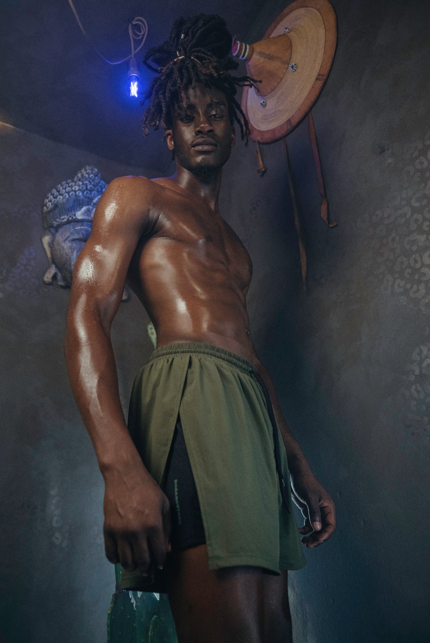 A person wearing the Jobari Shorts from Ruin Rally, which feature military green and black outer shorts with a graphic pattern on the inner shorts.