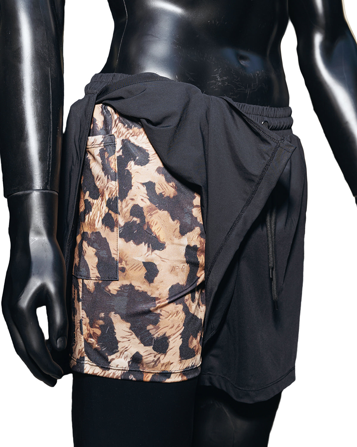 Mannequin in Duku shorts, which feature a Cheetah print inside short and black outer draping short. 