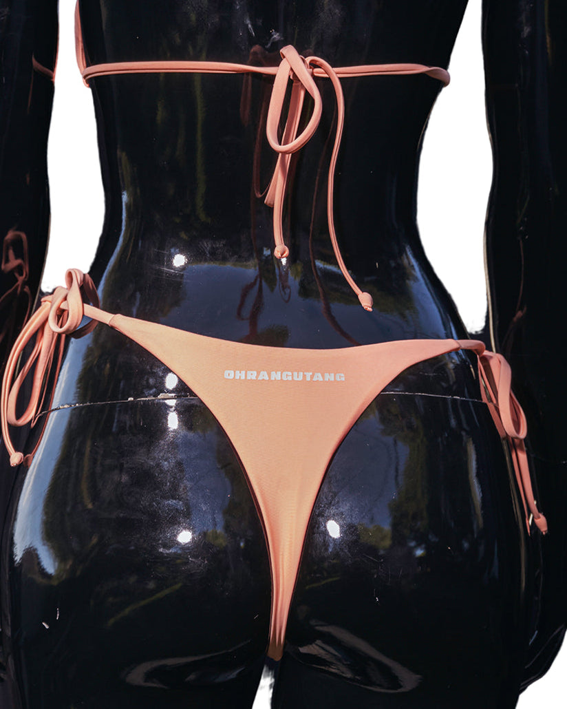 A rear view of a mannequin wearing a vivid peach bottom bikini, with the straps and the material visible.