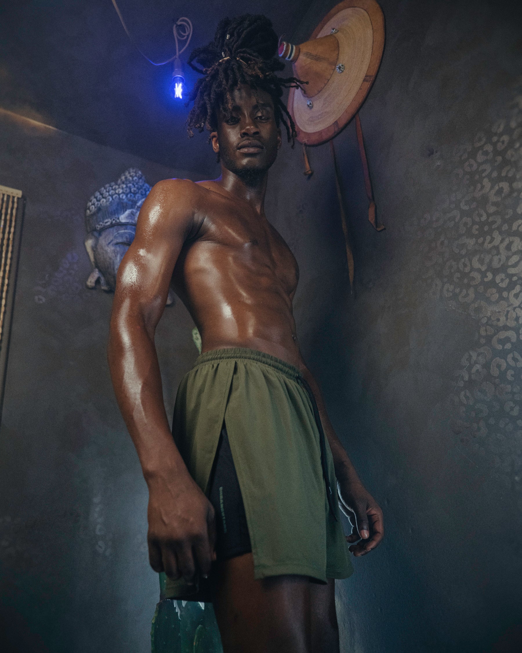 A person wearing the Jobari Shorts from Ruin Rally, which feature military green and black outer shorts with a graphic pattern on the inner shorts.