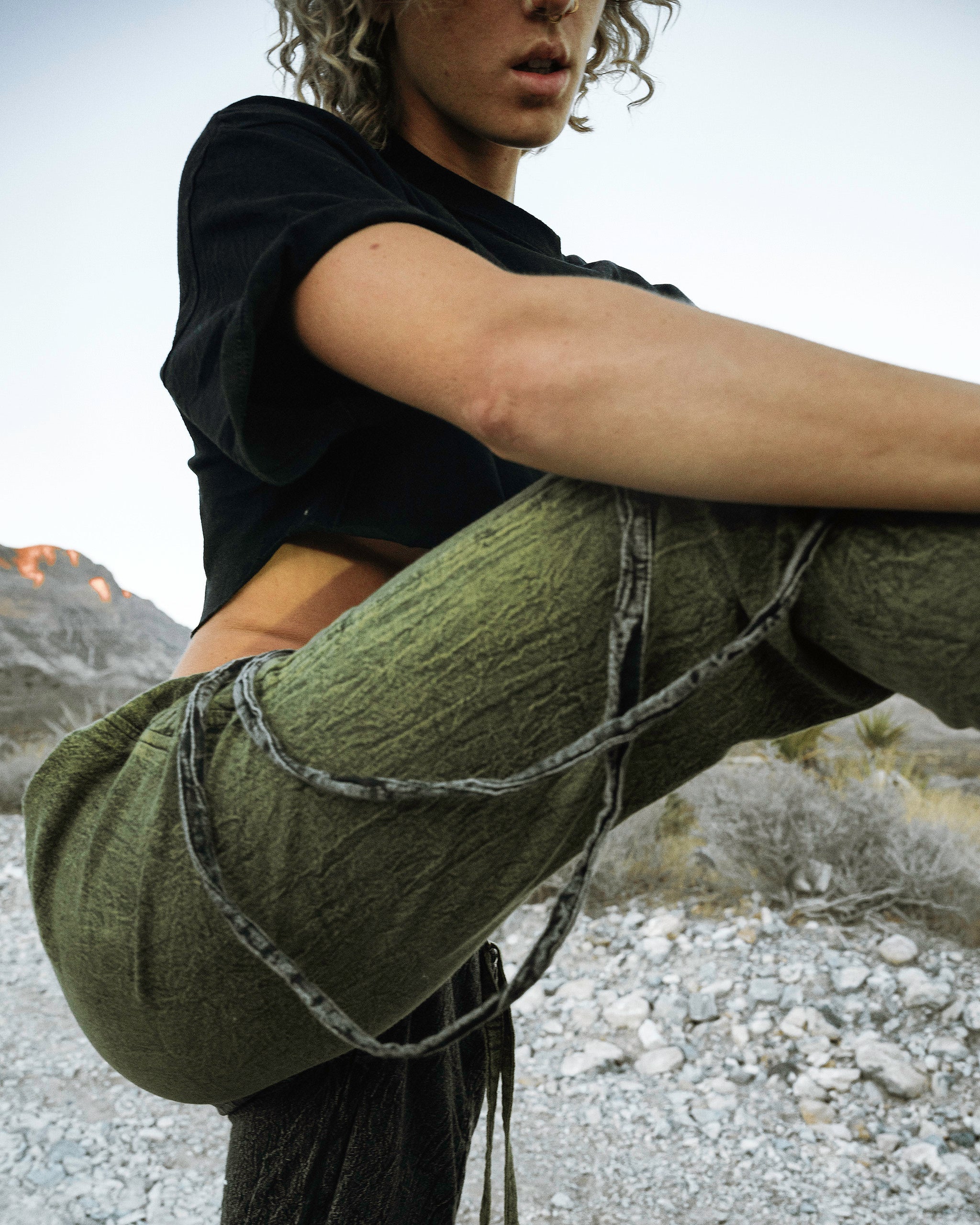Person wearing the Berghain pants standing in a desert.